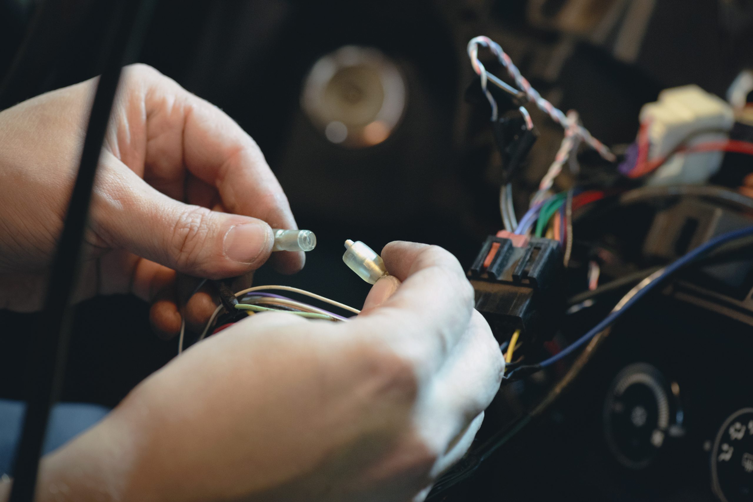 Auto electrician is installing a car radio sound system close up.