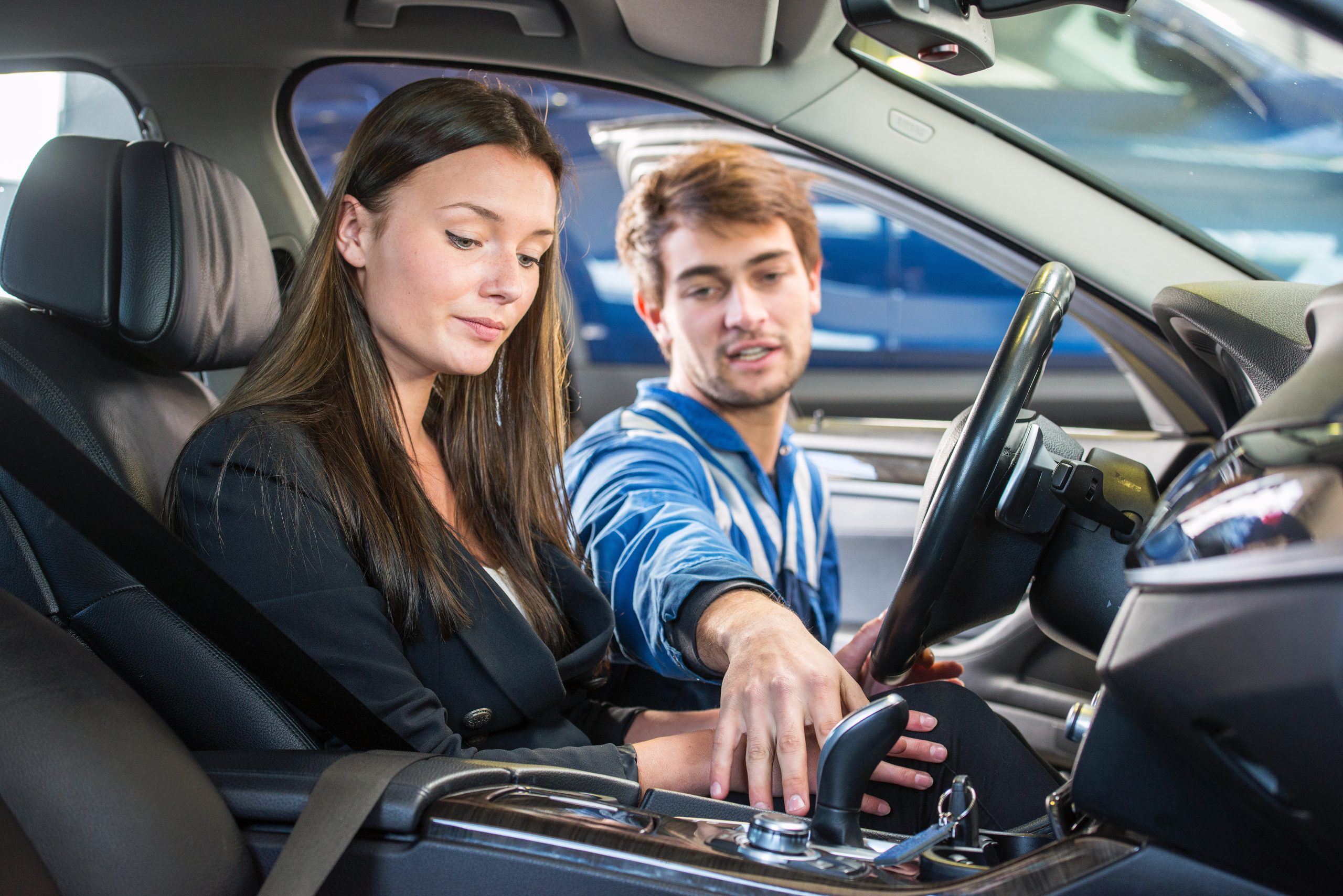 Mechanic demonstrating a second hand car to a potential customer
